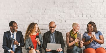 professionally dressed employees sitting in a row talking